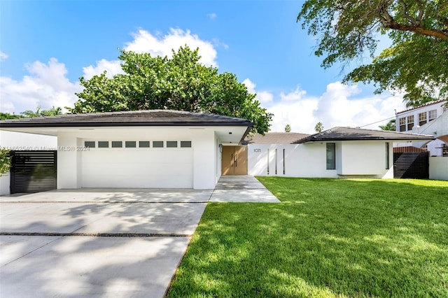 view of front of home with a front yard and a garage