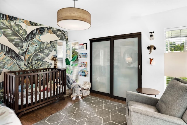 bedroom featuring dark hardwood / wood-style flooring and a crib