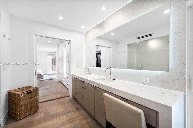 bathroom with hardwood / wood-style floors, vanity, and independent shower and bath