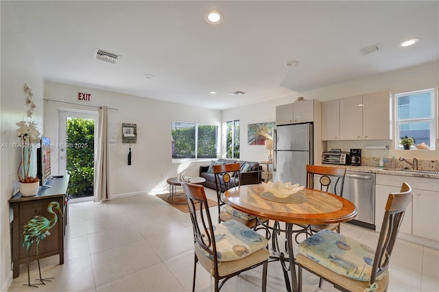 dining space with sink, a healthy amount of sunlight, and light tile patterned flooring