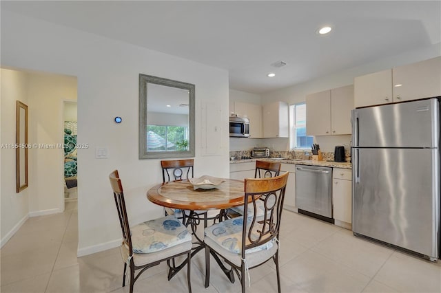 kitchen featuring light stone counters, light tile patterned floors, and stainless steel appliances