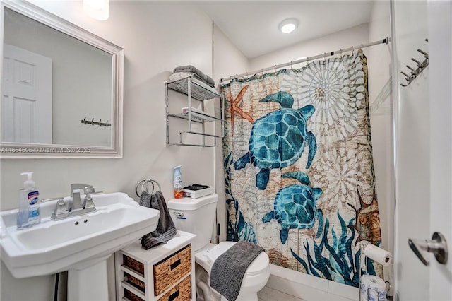 bathroom featuring sink, curtained shower, and toilet