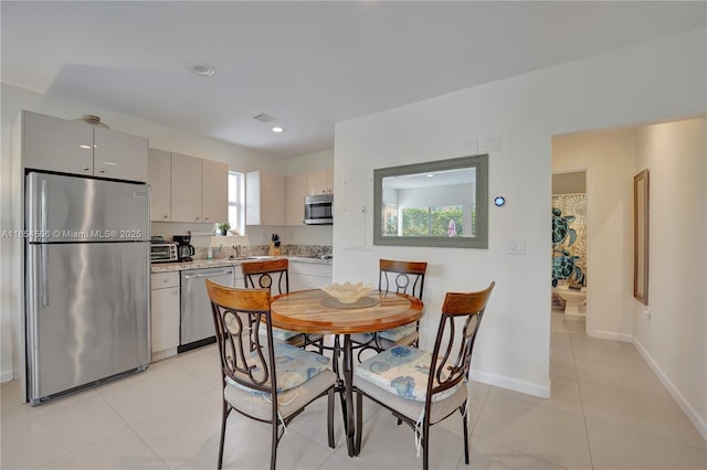 kitchen with sink, light tile patterned floors, and appliances with stainless steel finishes