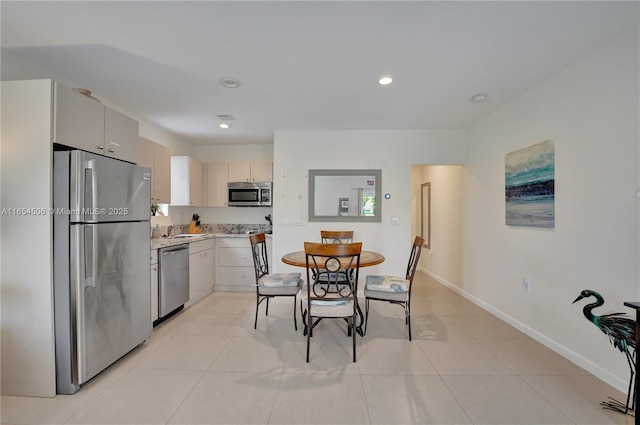 kitchen featuring light tile patterned flooring, appliances with stainless steel finishes, and sink