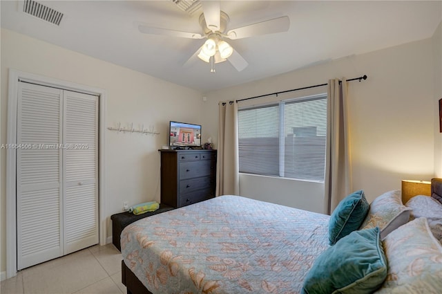 bedroom featuring light tile patterned floors, ceiling fan, and a closet