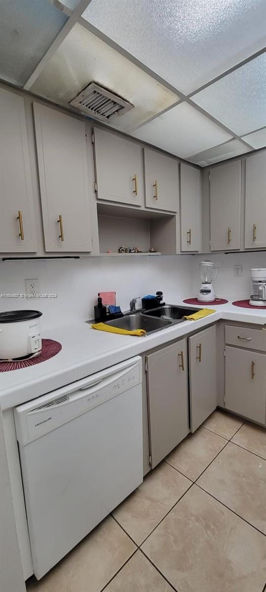 kitchen with dishwasher, light tile patterned floors, and gray cabinetry