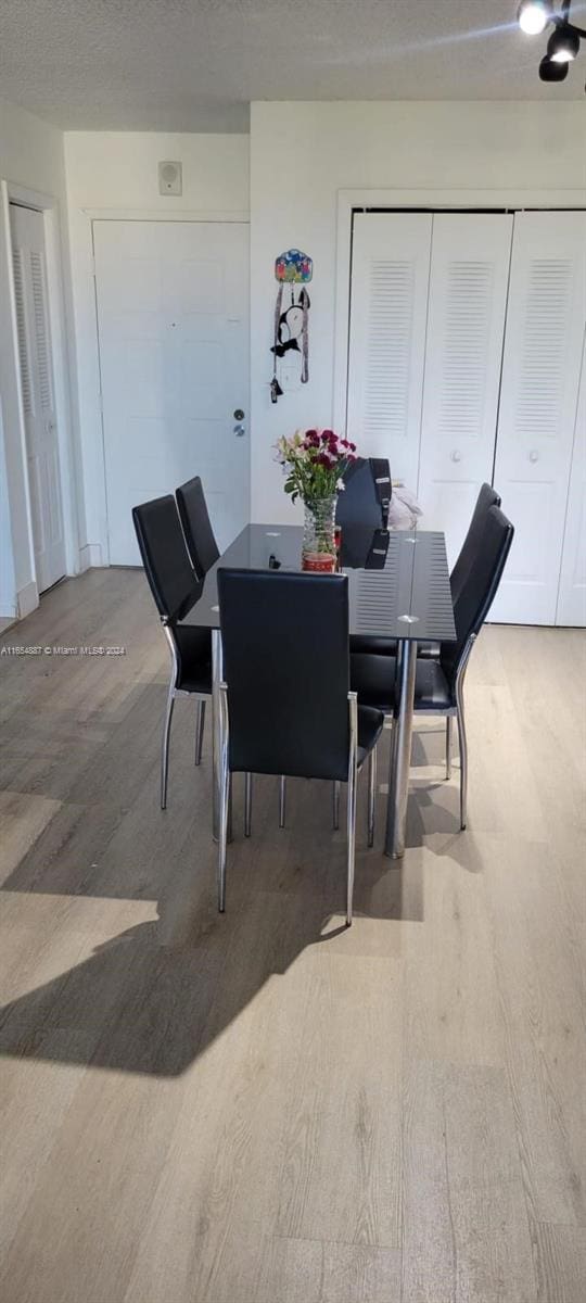 dining space with hardwood / wood-style flooring and a textured ceiling