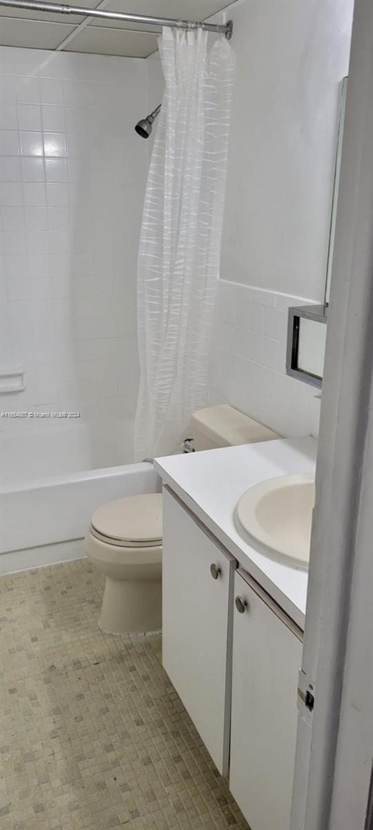 full bathroom with vanity, tile walls, shower / tub combo, and toilet