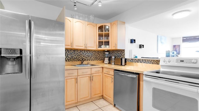 kitchen with light tile patterned floors, light brown cabinets, stainless steel appliances, and sink