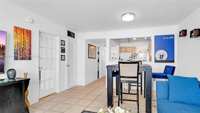 tiled dining room featuring rail lighting