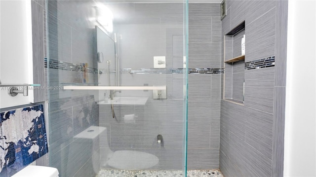 bathroom featuring toilet and a shower with door