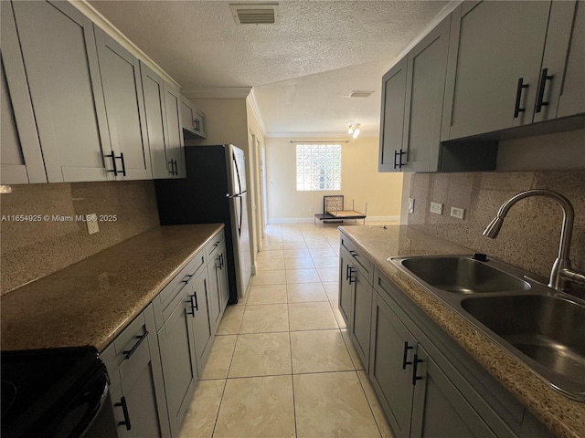 kitchen with range, tasteful backsplash, light tile patterned floors, and sink