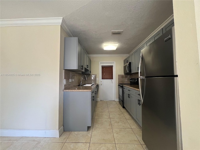 kitchen with gray cabinetry, decorative backsplash, sink, and appliances with stainless steel finishes