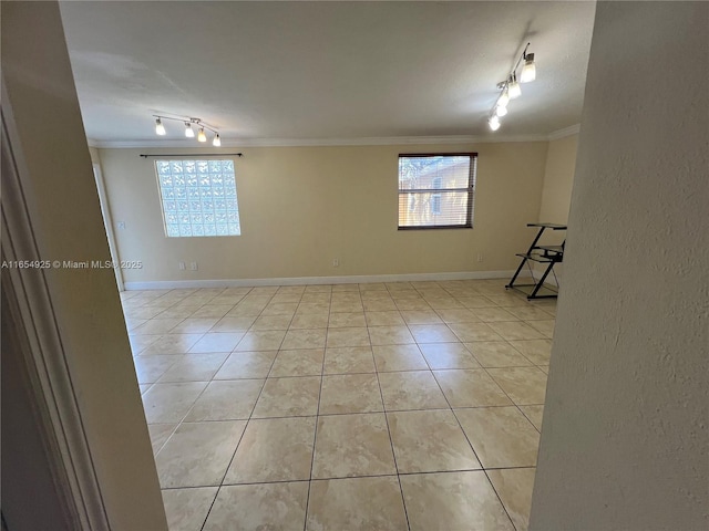 tiled empty room featuring crown molding