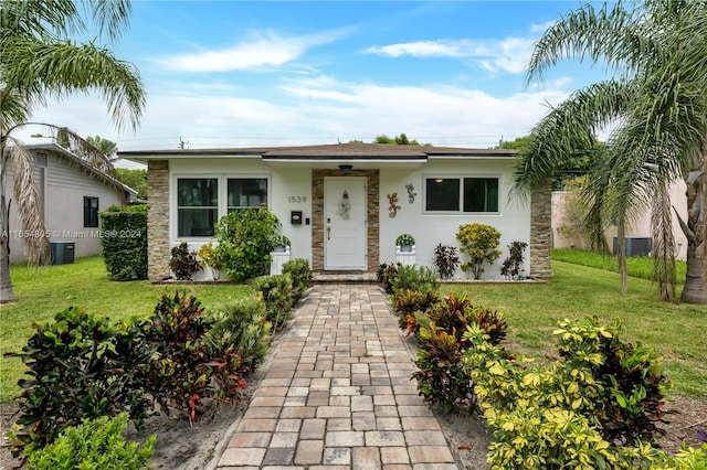 ranch-style house with cooling unit and a front yard