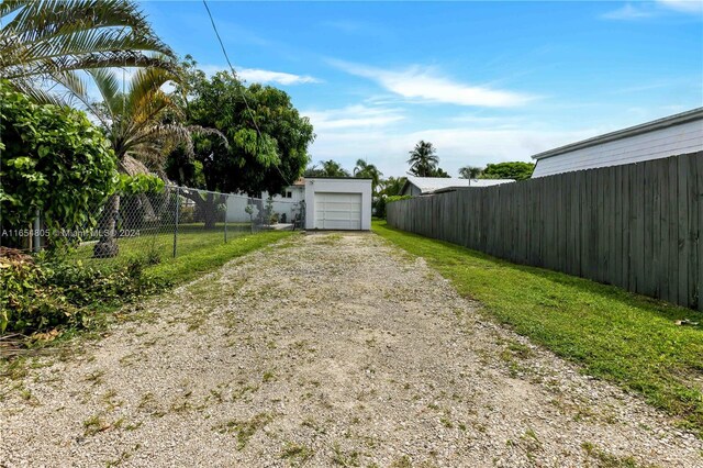 1539 Funston St, Hollywood, FL 33020 - view of yard with driveway, an outbuilding, fence, and a garage