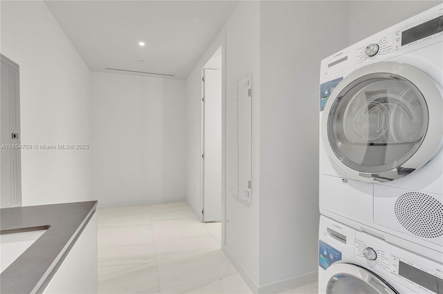 laundry area featuring stacked washer / dryer and sink