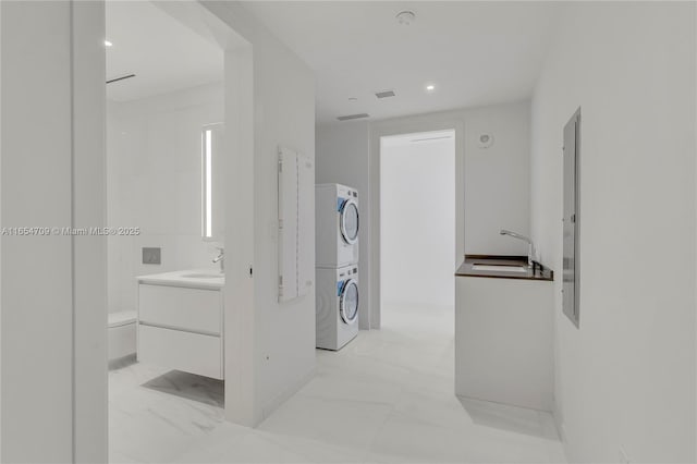 interior space featuring sink and stacked washer / drying machine