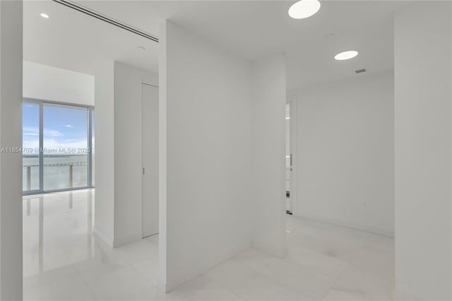 hallway with light tile patterned floors and a water view