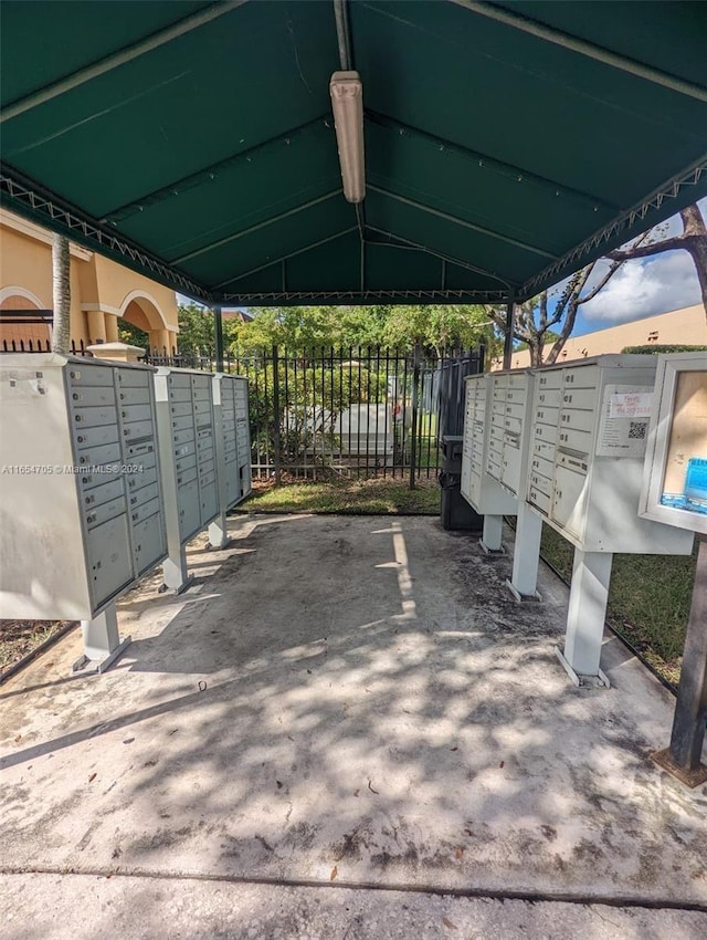 surrounding community featuring mail area, fence, and a carport