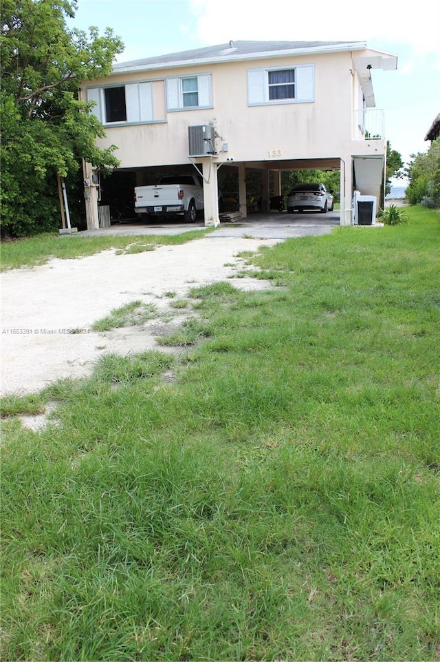 view of front of property featuring a carport, dirt driveway, and central AC unit