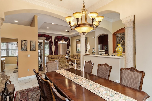 tiled dining space featuring a notable chandelier, crown molding, and ornate columns