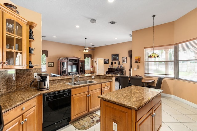 kitchen with ceiling fan, black dishwasher, dark stone counters, and sink