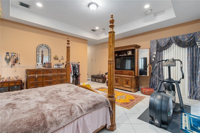 tiled bedroom featuring a raised ceiling