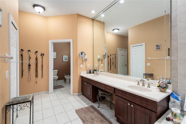 bathroom featuring a bidet, vanity, toilet, and tile patterned floors