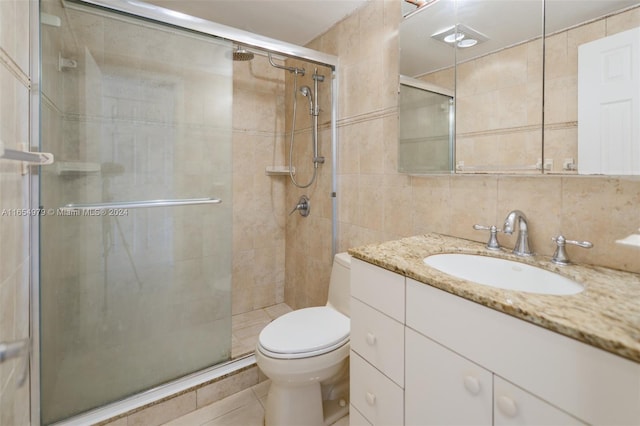 bathroom with toilet, walk in shower, vanity, decorative backsplash, and tile walls