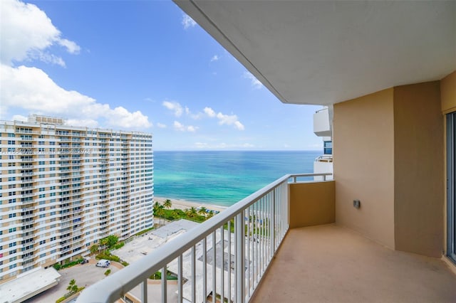 balcony with a water view and a view of the beach