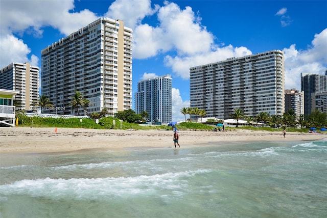 view of property featuring a water view and a beach view