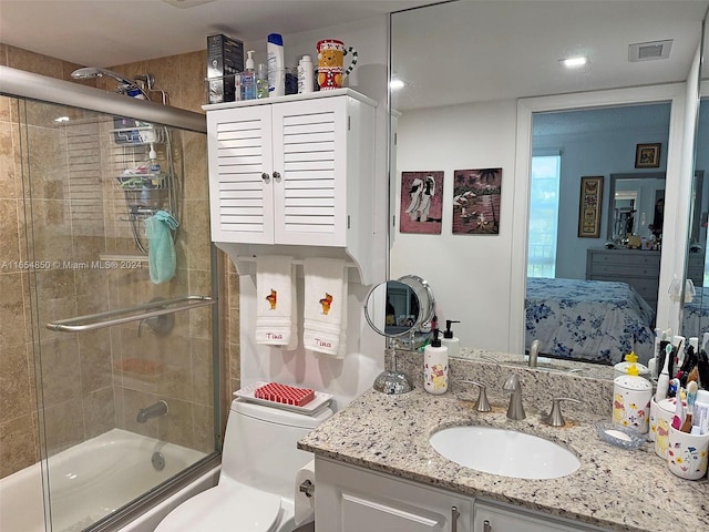 full bathroom featuring vanity, toilet, and bath / shower combo with glass door