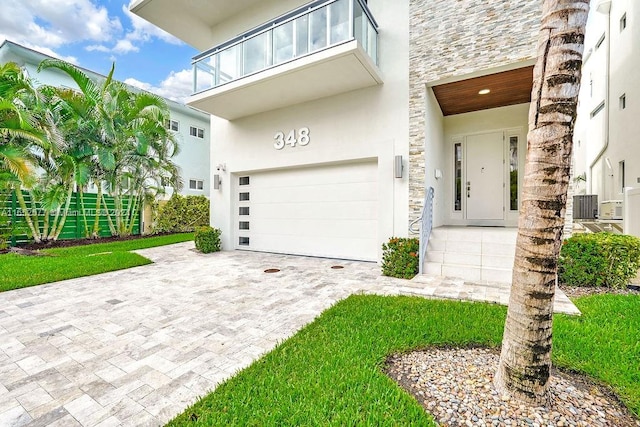 view of front of home featuring a balcony, a garage, and a front lawn