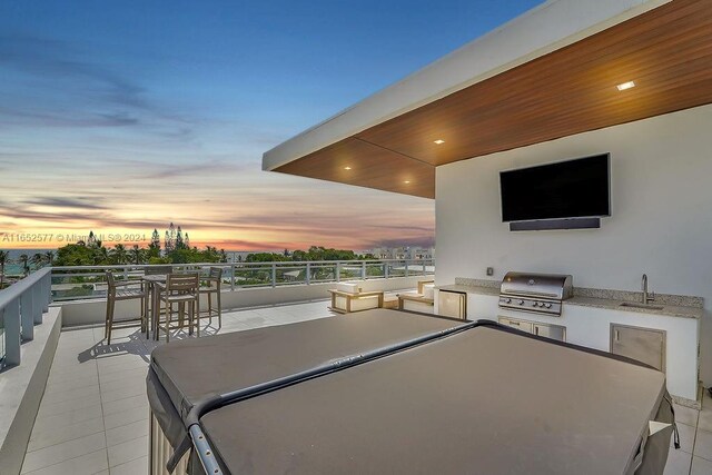 view of patio with a balcony, grilling area, an outdoor kitchen, and sink