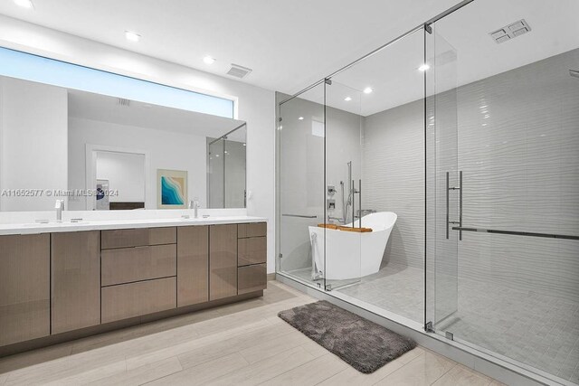 bathroom with vanity, independent shower and bath, and wood-type flooring