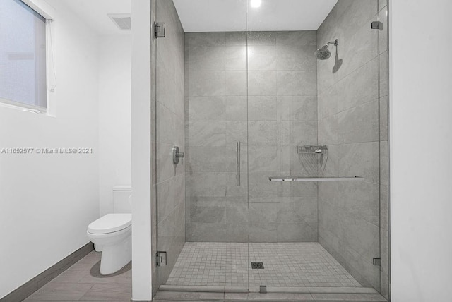 bathroom featuring toilet and a shower with door