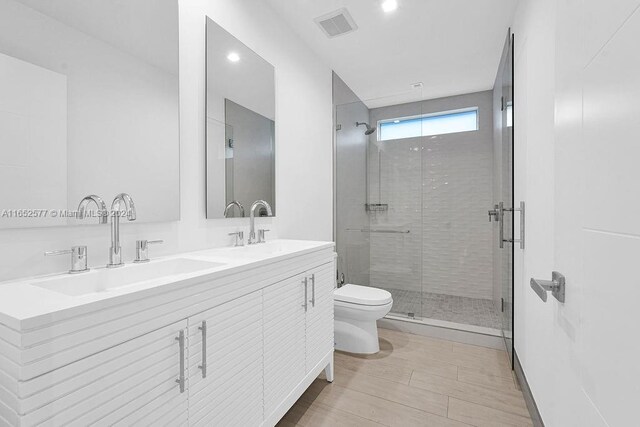 bathroom featuring walk in shower, toilet, wood-type flooring, and vanity