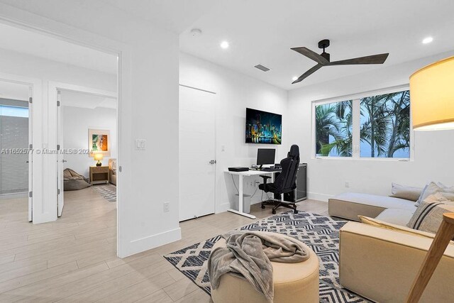 office space featuring a wealth of natural light, light hardwood / wood-style flooring, and ceiling fan