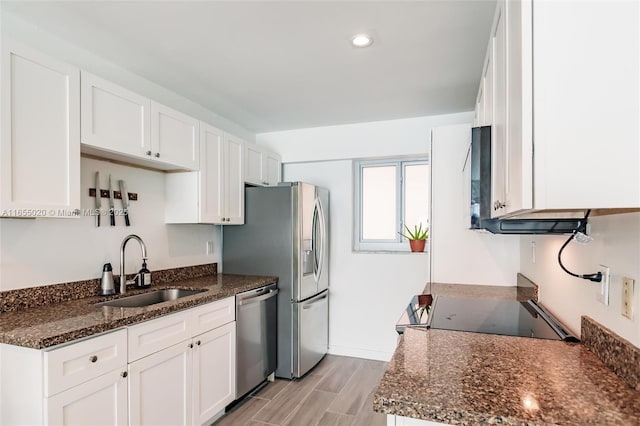 kitchen with sink, white cabinetry, dark stone countertops, and stainless steel appliances