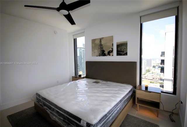 bedroom featuring tile patterned floors, multiple windows, and ceiling fan