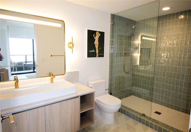 bathroom featuring tiled shower, vanity, and toilet