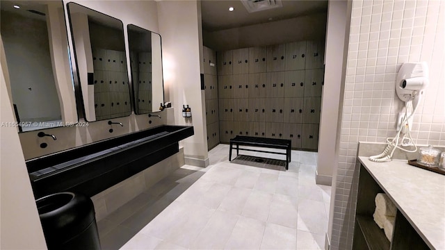 bathroom featuring tile walls, tile patterned flooring, and vanity