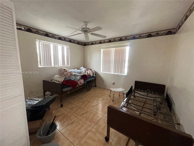 bedroom featuring tile patterned floors, ceiling fan, and multiple windows