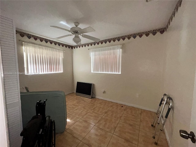 spare room featuring tile patterned floors and ceiling fan