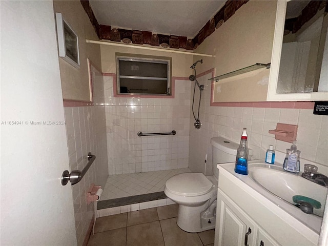 bathroom featuring tile patterned floors, vanity, toilet, and tile walls