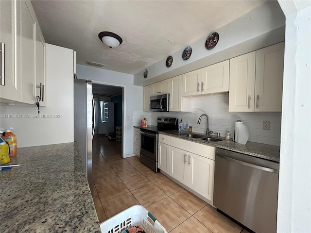 kitchen featuring white cabinetry, sink, dark stone counters, and appliances with stainless steel finishes