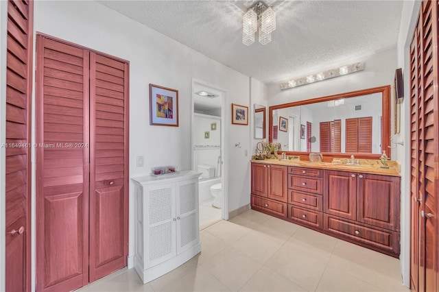 bathroom featuring tile patterned flooring, vanity, a textured ceiling, and toilet