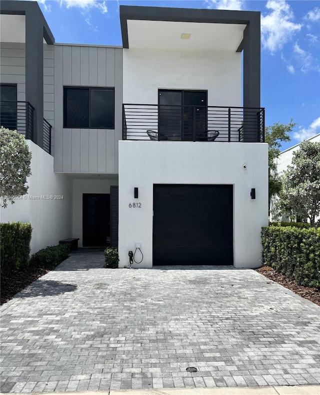 contemporary house with a garage and a balcony