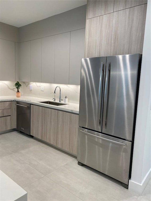 kitchen featuring stainless steel appliances, sink, decorative backsplash, and light brown cabinetry